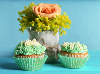 Tasty cupcakes on table, on turquoise background