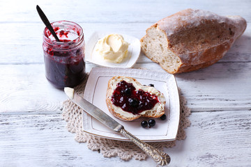 Fresh bread with homemade butter and blackcurrant jam