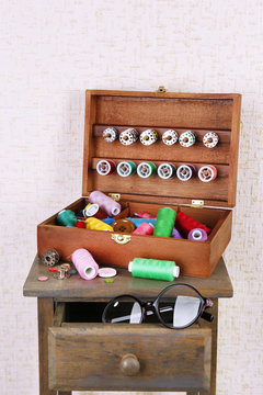 Colorful threads for needlework in wooden box close up