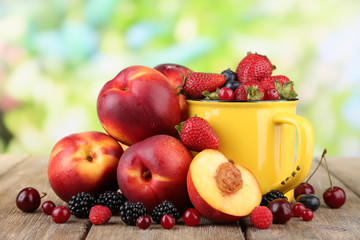 Peaches and berries on table on natural background