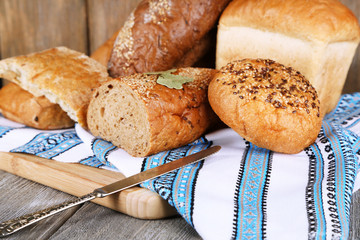 Composition of fresh baked bread, knife and kitchen towel,