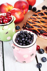 Sweet berries and berry tart on table close-up