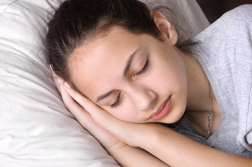 Fototapeta na wymiar Young girl sleeping in bed