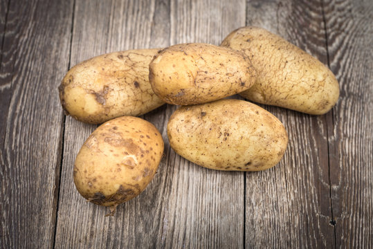 Potatoes on wooden background.