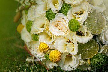 Wedding bouquet from beige roses, cinnamon, a lemon, a lime