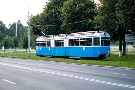 Municipal blue tram rides through the roads of the city