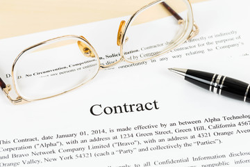 Business contract document with pen and glasses