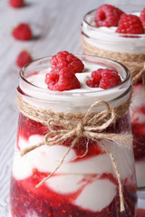 fresh raspberry yogurt in a glass jar closeup on table vertical