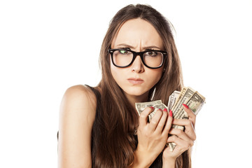 stingy beautiful woman holding her money - obrazy, fototapety, plakaty