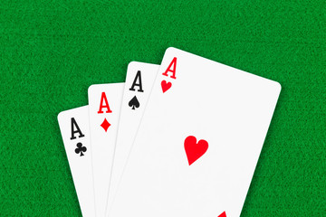 Four aces on green felt background
