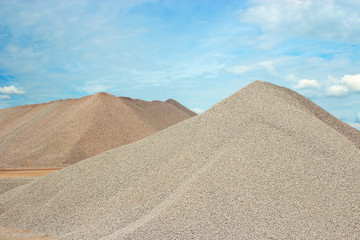 Sand heaps with blue sky in gravel quarry