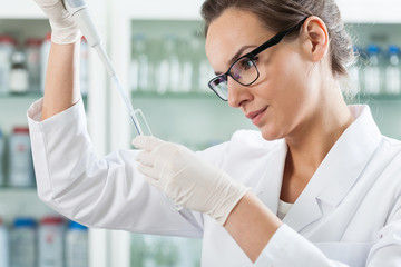 Scientist using pipette in laboratory
