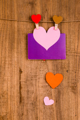 colorful paper heart hanging on wooden background