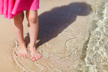 Fototapeta na wymiar Close up of little girl standing at beach