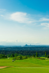 Fototapeta na wymiar Golf Course with Green Grass and Seattle Downtown at the Backgro