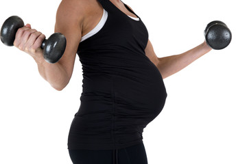 Fototapeta na wymiar Pregnant model lifting heavy barbells side view close-up