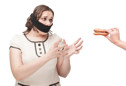 Plus size woman gagged stretching hands to hamburger