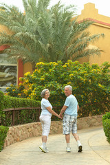 Fototapeta na wymiar Elder couple in exotic garden