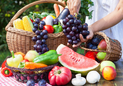 Various fruits and vegetables, grapes in hands
