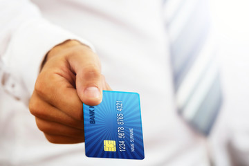 Close up of a businessman`s hand,holding blue credit card.