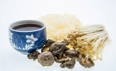 cup of tea and mushroom varieties over white background