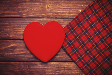 Heart shape and sscarf on wooden table.