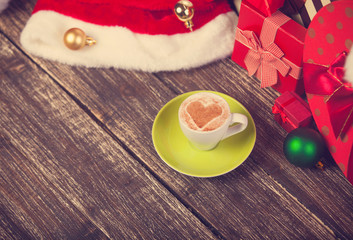 Cup of coffee with heart shape with christmas gifts.