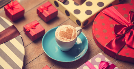Cup of coffee and christmas gifts.