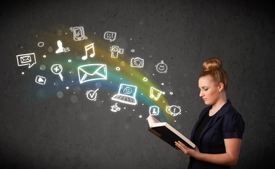 Young woman reading a book with multimedia icons coming out of t