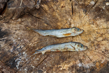 Two small dried fishes on  wood