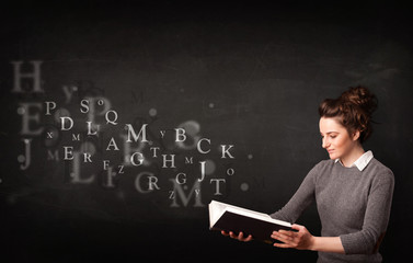 Young lady reading a book with alphabet letters