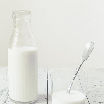total white polaroid of fresh milk on glass and on bottle