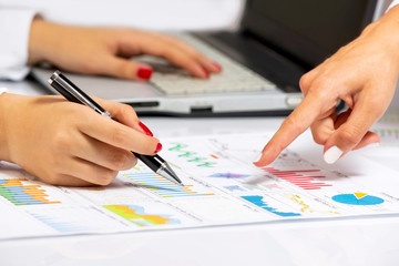 Female hands doing research on office desk, at business meeting.