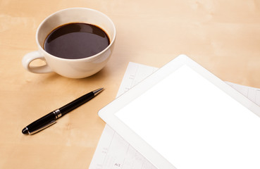 Tablet pc with empty space and a cup of coffee on a desk