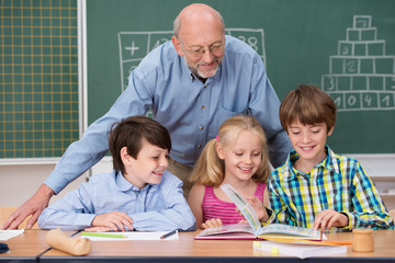 kinder in der schule blättern zusammen in einem buch