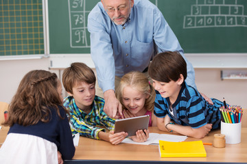 kinder und lehrer schauen auf tablet