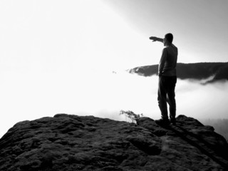 Obraz premium Man on rock watch over the morning misty valley to big Sun. 