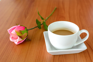 Close up of cup of coffee with pink rose