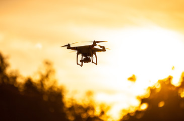 Photo of a quadrocopter on sunset sky - obrazy, fototapety, plakaty