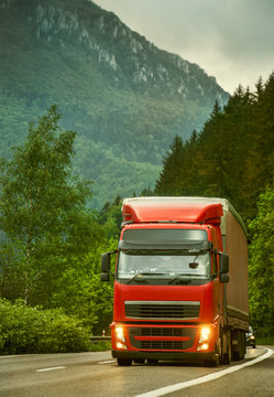 Red truck on mountain highway in the evening