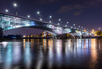 Fototapeta na wymiar Backlit bridge at night and reflected in the water.