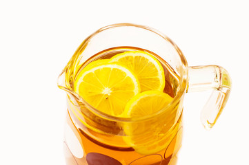 Cooling lemonade with lemon slices in a glass jug