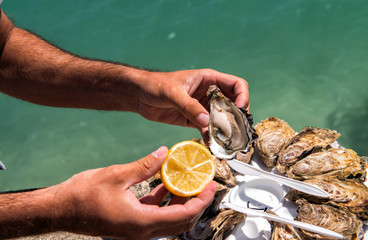 Fototapeta premium Man hands with lemon and oyster