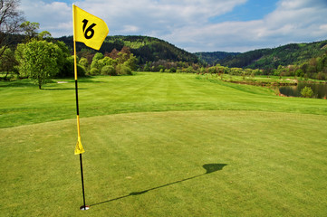 Obraz premium Yellow flag in the hole on the green golf course
