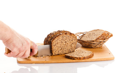 Fresh bread.  Slicing Bran Bread on a Cutting Board.  hands cutt