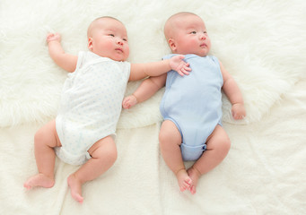 Twins baby lying on bed