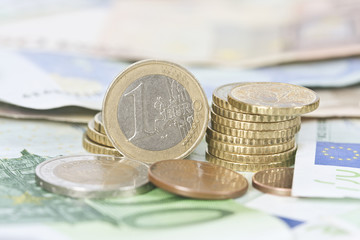 coins stacked in the foreground with notes and documents