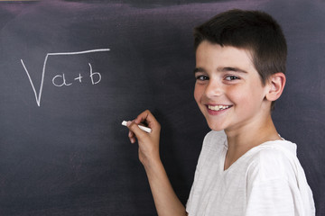 child in school blackboard with mathematical formula