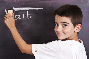 child in school blackboard with mathematical formula
