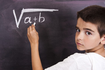 child in school blackboard with mathematical formula